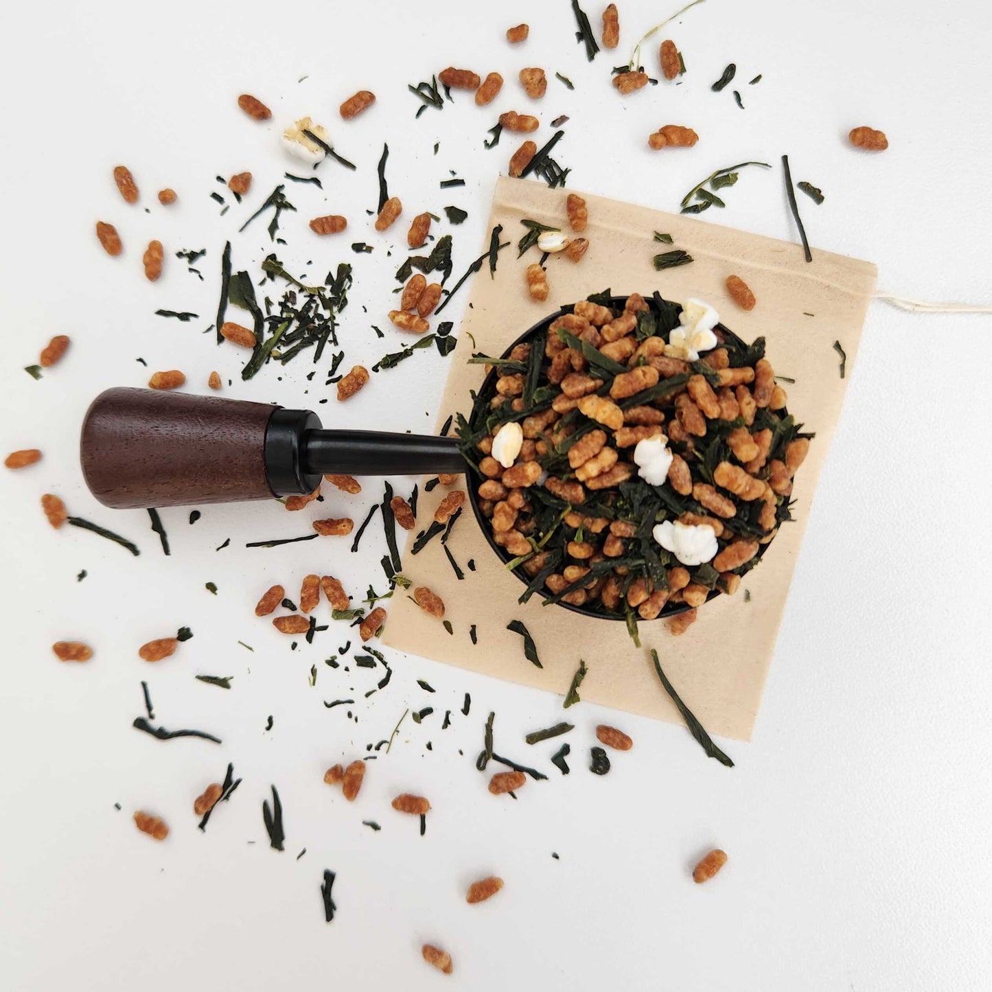 Monimo biodegradable and home compostable eco-friendly teabag pictured with Premium Japanese Genmaicha green tea leaves.