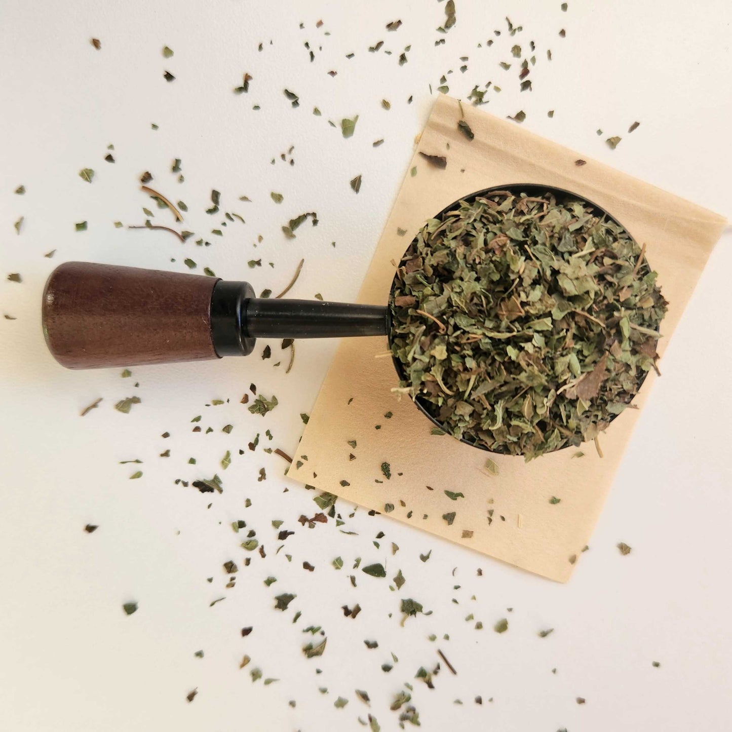 Monimo biodegradable and home compostable eco-friendly teabag pictured with Lemon Balm tea leaves.