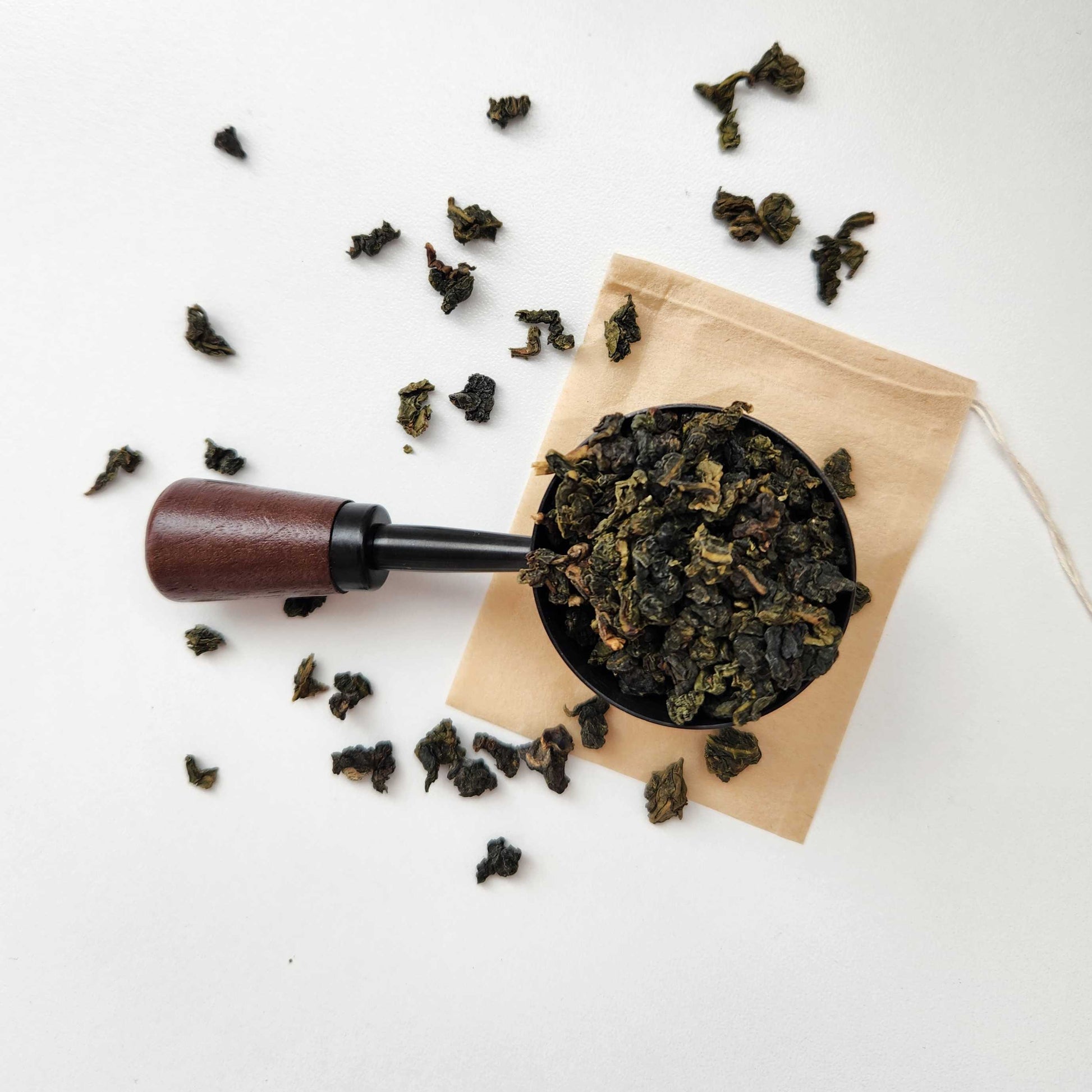 Monimo biodegradable and home compostable eco-friendly teabag pictured with Premium Tie Guan Yin oolong tea leaves. 